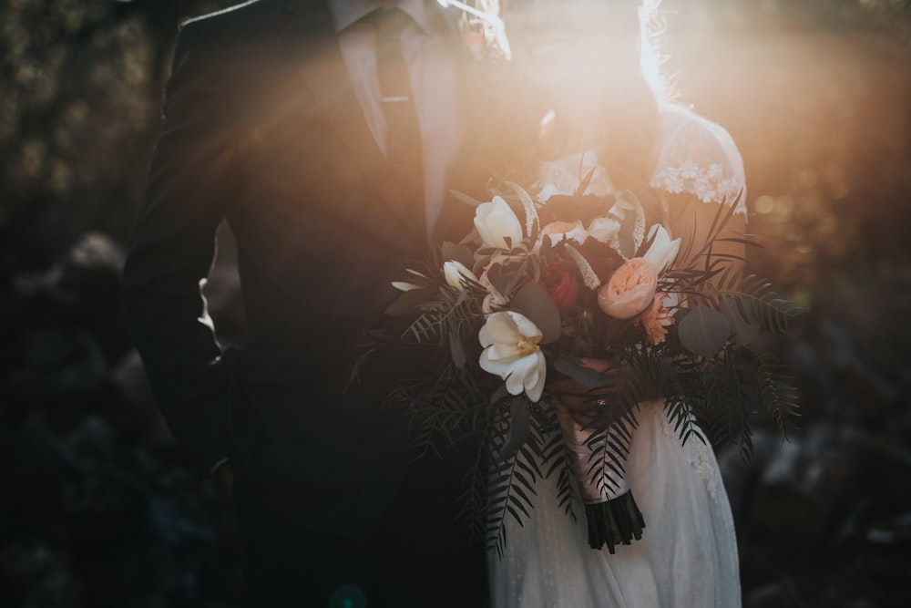 Bride and groom holding a bouquet at golden hour