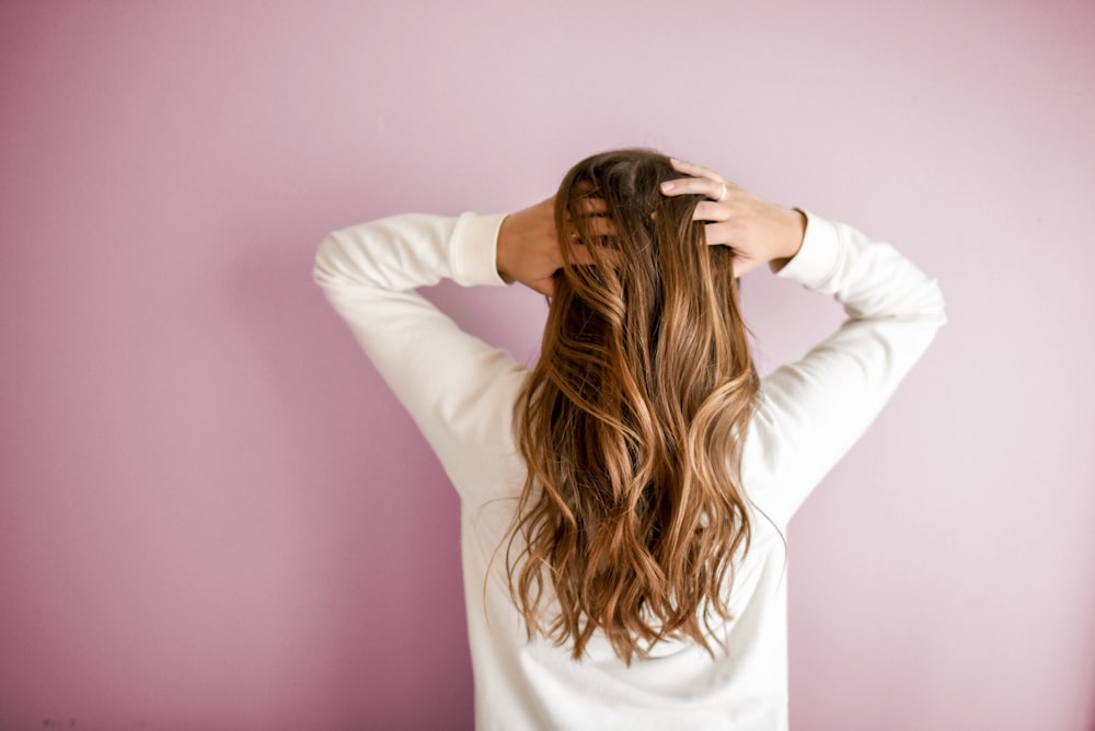 Woman with long wavy hair running her hands through it